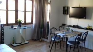a living room with a table with chairs and a tv at Apartment Luz & Luna in Villajoyosa