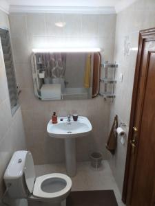 a bathroom with a sink and a toilet and a mirror at Apartment Luz & Luna in Villajoyosa +6 photos