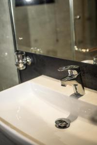 a bathroom sink with a faucet and a mirror at Kevans Casa in Mahiyangana