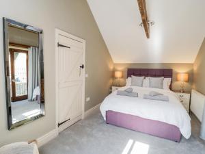 a bedroom with a large bed and a large mirror at Woodside Barn in Thirsk