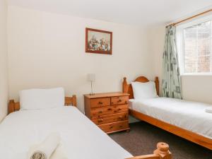two twin beds in a room with a window at Orchid in Filey