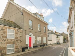 a brick building with a red door on a street at Ocean View in Marazion