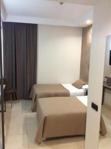 una camera d'albergo con tre posti letto di Hotel Ciudad de Fuenlabrada a Fuenlabrada