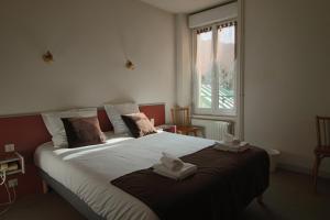 a bedroom with a large bed with towels on it at Hotel Au Val Doré in La Bourboule