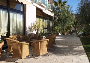 eine Gruppe von Stühlen und Tischen auf einer Terrasse in der Unterkunft Hotel Ariston & Apartments in Varraze