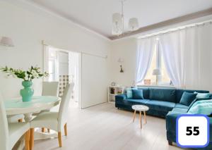 Sienna 41 Boutique Warsaw Apartments في وارسو: غرفة معيشة مع أريكة زرقاء وطاولة
