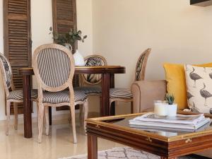 a living room with a coffee table and chairs at Poseidon's Luxury Apartment in Paphos