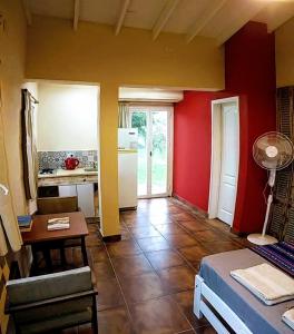 sala de estar con paredes rojas, mesa y cocina en apartamento VINTAGE IVA en Merlo