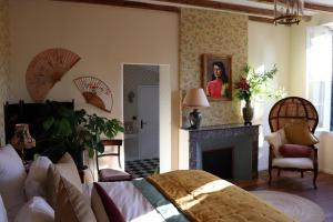 ein Wohnzimmer mit einem Bett und einem Kamin in der Unterkunft Manoir Laurette in Saint-Martin-Petit