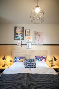 1 dormitorio con 1 cama y 2 lámparas y cuadros en la pared en Casa ViniToscani en Perroy