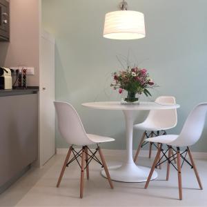 una mesa blanca con sillas blancas y un jarrón de flores en Santa Chiara Suite en Turín