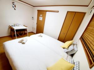 um quarto com uma grande cama branca e uma mesa em Takaraboshi room 201 Sannomiya 10 min em Kobe