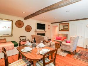 a living room with a table and chairs and a couch at Chapel Cottage in Stroud