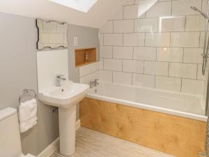 a bathroom with a sink and a bath tub at May Cottage in Scarborough +12 photos
