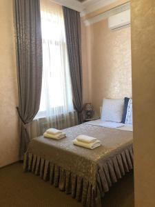 a bedroom with a bed with two towels on it at Гостиный Двор Надежда in Khlibodarske