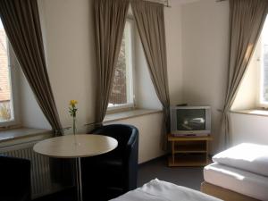 a living room with a table and a tv at Landgasthof Wellmann in Markt Taschendorf