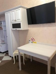 a kitchen with a white table and a microwave at Гостиный Двор Надежда in Khlibodarske