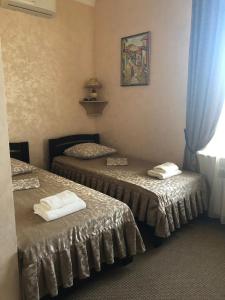 two beds in a hotel room with towels on them at Гостиный Двор Надежда in Khlibodarske