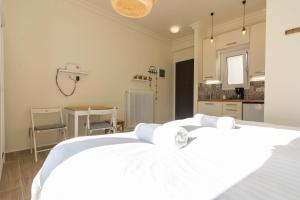 1 Schlafzimmer mit 2 weißen Betten und einer Küche in der Unterkunft Birds Nest in Athen