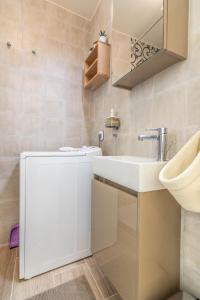 ein Badezimmer mit einem weißen Waschbecken und einem Spiegel in der Unterkunft Birds Nest in Athen