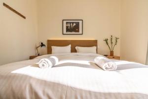 ein Schlafzimmer mit einem weißen Bett und Handtüchern darauf in der Unterkunft Birds Nest in Athen