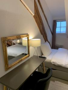 a bedroom with a mirror and a desk with a bed at smartroom The Residence la Cittadella Baden in Baden