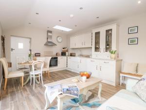 a kitchen and living room with a table and a couch at 1 Church Barns in Great Driffield