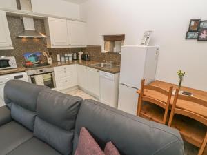 uma sala de estar com um sofá e uma cozinha em The Stable em Penzance