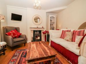 a living room with a white couch and a fireplace at October Cottage in Stroud