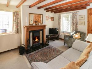 a living room with a fireplace and a couch at Howe Green Cottage in York