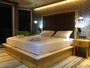 een slaapkamer met een groot wit bed met een houten frame bij Sunset Beach Hotel in Mirissa