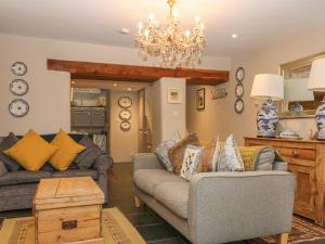 een woonkamer met 2 banken en een kroonluchter bij Weavers Cottage in Nailsworth
