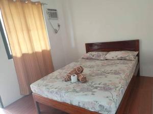 a bed with a teddy bear and a cup on it at Two Season Tourist Inn in San Vicente