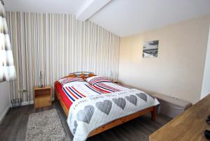 ein Schlafzimmer mit einem Bett in einem Zimmer mit Streifen in der Unterkunft Käptn's Stuv in Hörnum