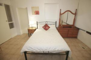een slaapkamer met een bed met een spiegel en een dressoir bij Sunny House - Melbourne Airport Home in Melbourne