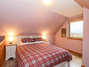 a bedroom with a bed and a window at Little Tigh Clovelly in Spean Bridge