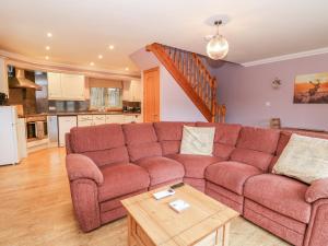 a living room with a couch and a table at Little Tigh Clovelly in Spean Bridge