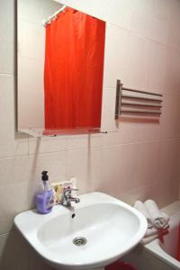 ein Badezimmer mit einem Waschbecken und einem roten Duschvorhang in der Unterkunft Apartamento Feria 2 in Sevilla