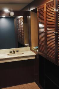 ein Bad mit einem Waschbecken und einem Spiegel in der Unterkunft Aguada Hotel in Trelew