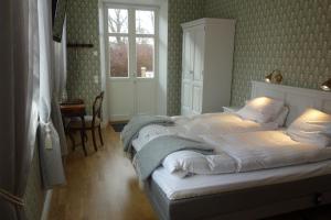Schlafzimmer mit einem großen weißen Bett und einem Fenster in der Unterkunft Kastanjelund in Yngsjö