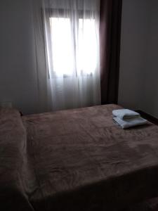 un letto in una stanza con una finestra con asciugamani di Casa Roberta ad Arona