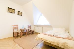 een slaapkamer met een bed en een tafel en stoelen bij Apartament Elmal Pardałówka in Zakopane