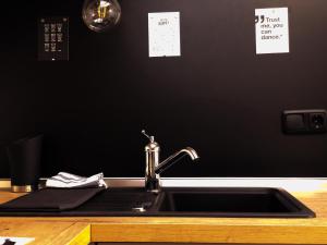 un lavandino con rubinetto e parete nera di Ferienwohnung Alpzeit a Blaichach