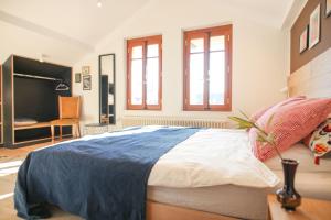 a bedroom with a bed and a desk and windows at Casa ViniToscani in Perroy