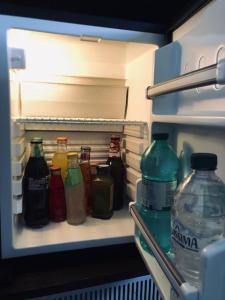 a refrigerator filled with bottles of soda and water at Hotel Eremo in Soriano nel Cimino