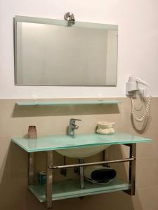 W łazience znajduje się umywalka z lustrem i telefon. w obiekcie Hotel Eremo w mieście Soriano nel Cimino