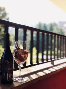 a bottle of wine and a wine glass on a balcony at Hotel Eremo in Soriano nel Cimino