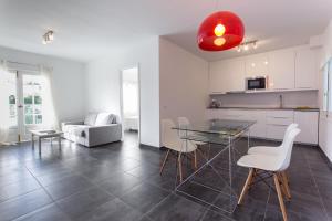 cocina y sala de estar con mesa de cristal y sillas en Apartamento Gama 1 habitación, en Cala Galdana