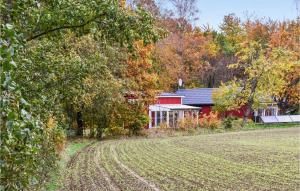ein rotes Haus mit einem Feld davor in der Unterkunft Beautiful Home In Veberd With House A Panoramic View in Veberöd