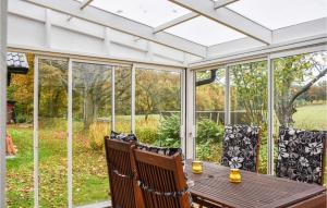 a screened in porch with a table and chairs at Beautiful Home In Veberöd With Wifi in Veberöd +6 photos